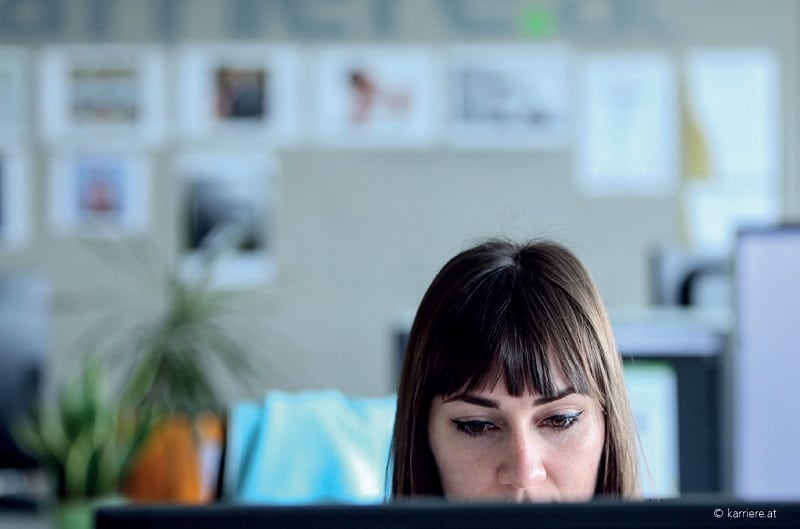 Frau sitzt vor Monitor