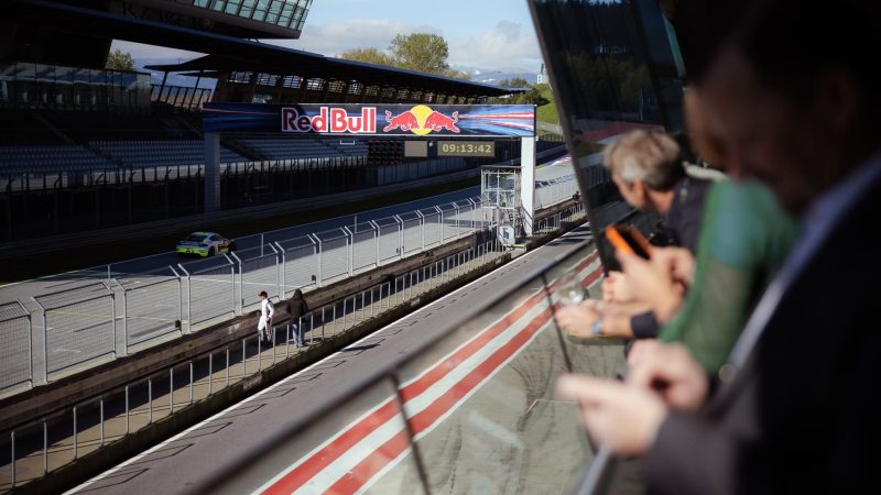 Besucher des Porsche Cup Events von XiTrust beobachten das Renngeschehen